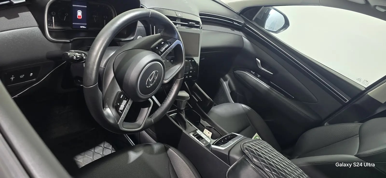 Clean Hyundai driver's cabin with black seats