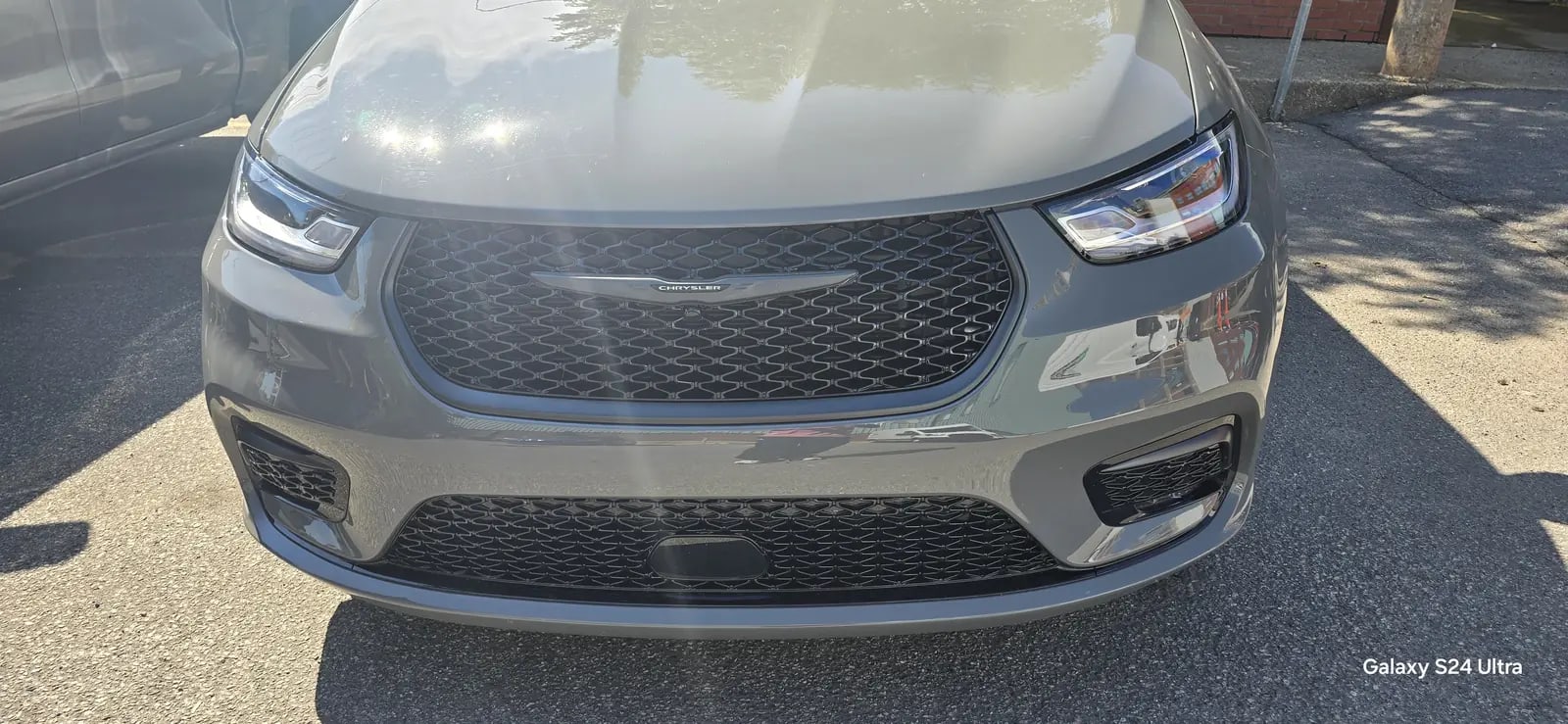 Clean grey minivan front end in daylight